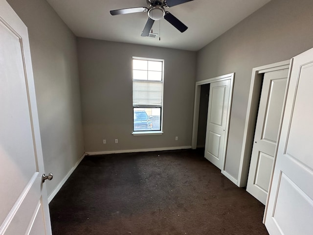 unfurnished bedroom with dark carpet and ceiling fan