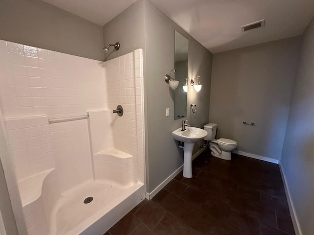 bathroom with walk in shower, tile patterned floors, and toilet