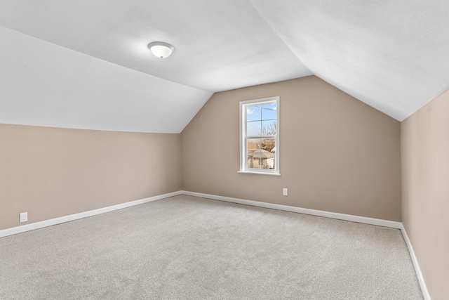 additional living space with vaulted ceiling, baseboards, and carpet floors