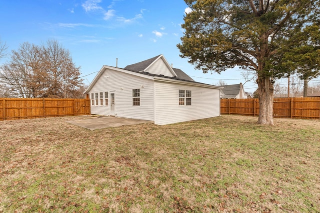 rear view of property with a yard and a patio