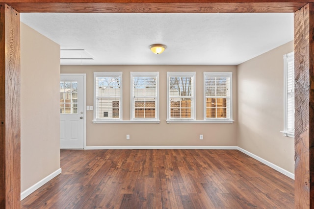 interior space with baseboards, attic access, and hardwood / wood-style flooring