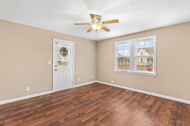 empty room with dark wood-style floors, baseboards, and a ceiling fan