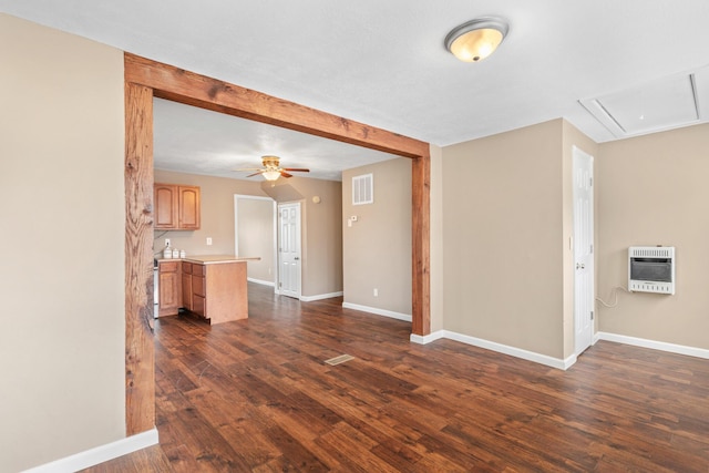 unfurnished living room featuring visible vents, a ceiling fan, heating unit, baseboards, and dark wood-style flooring