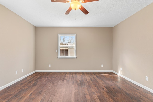 empty room with a textured ceiling, dark wood-type flooring, baseboards, and ceiling fan