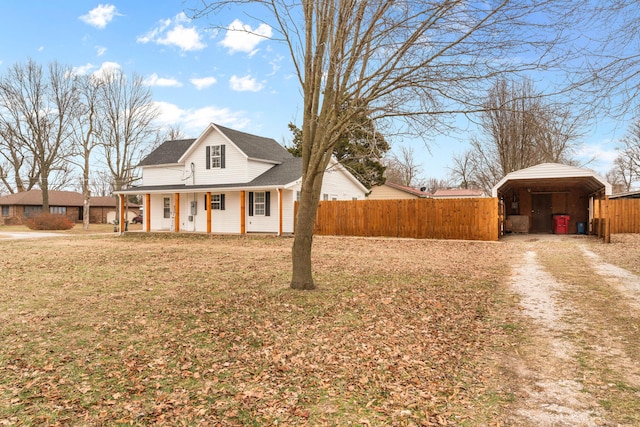 view of front of house featuring a carport, covered porch, and a front lawn