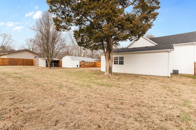 view of yard with an outbuilding, a storage shed, and fence