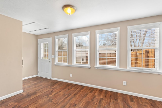 unfurnished room featuring plenty of natural light and dark wood-type flooring