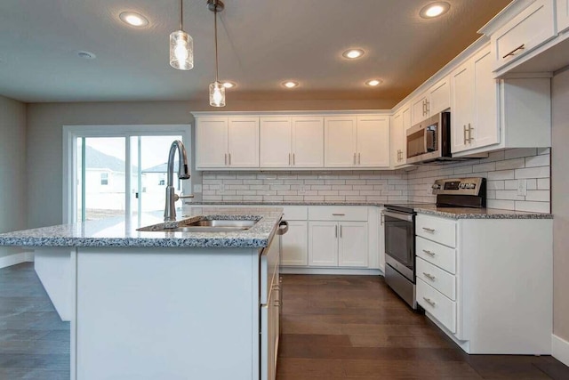 kitchen featuring pendant lighting, stainless steel appliances, sink, and white cabinets