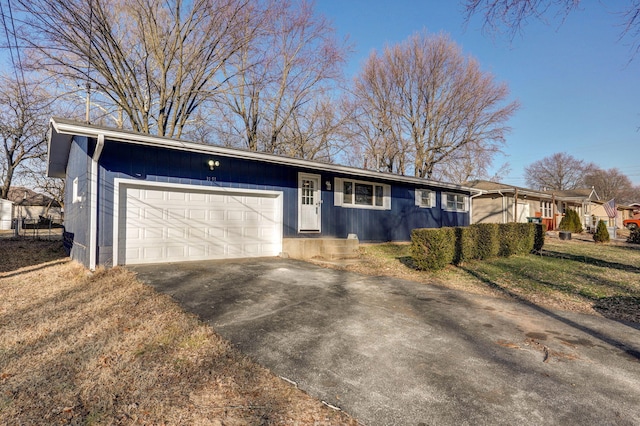 ranch-style house with an attached garage and aphalt driveway