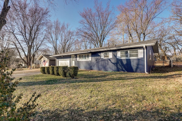 ranch-style house featuring a garage, fence, and a front yard