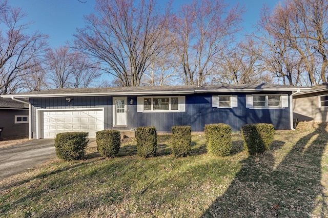 ranch-style home featuring a garage, driveway, and a front yard