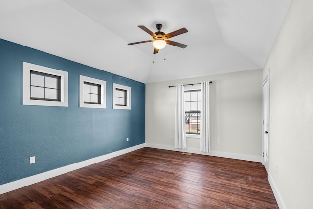 empty room featuring ceiling fan, dark hardwood / wood-style floors, and vaulted ceiling