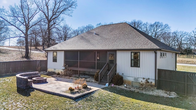 rear view of house featuring a yard, a fire pit, a sunroom, and a patio