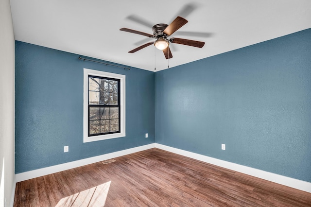 spare room with wood-type flooring and ceiling fan