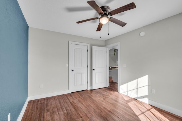 unfurnished bedroom with ceiling fan and hardwood / wood-style floors