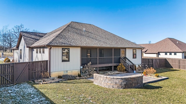 back of property with a yard, a patio area, and a sunroom