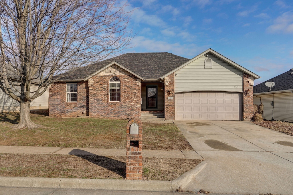 ranch-style home with a garage and a front lawn