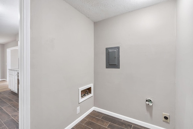 laundry room with hookup for an electric dryer, electric panel, hookup for a washing machine, and a textured ceiling