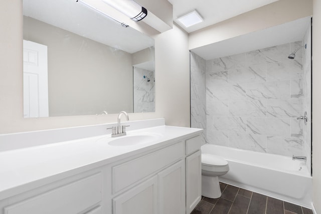 full bathroom with vanity, tiled shower / bath, and toilet