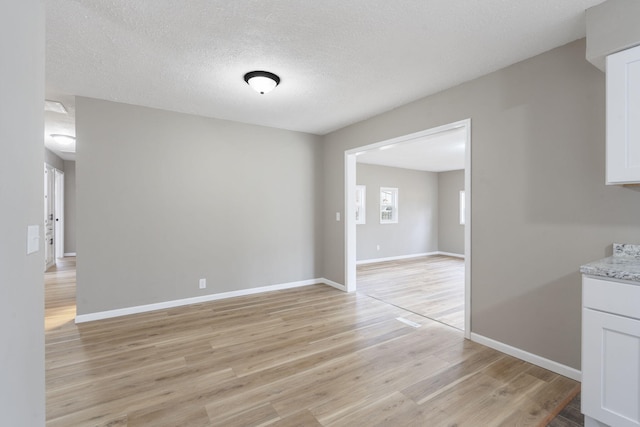 unfurnished dining area featuring light hardwood / wood-style floors and a textured ceiling