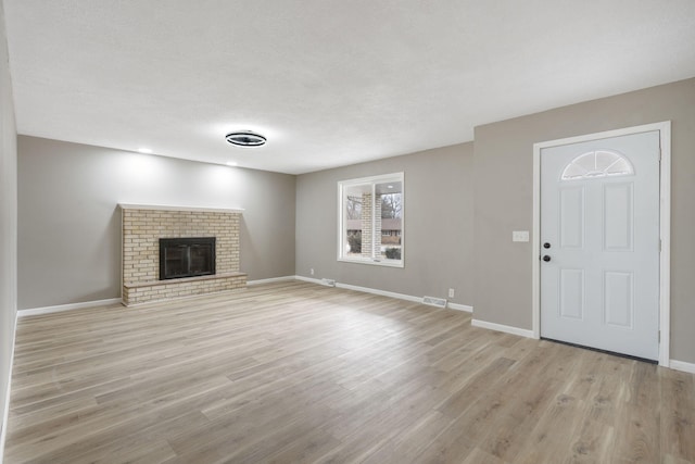 unfurnished living room with a fireplace and light hardwood / wood-style flooring