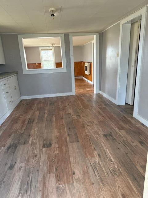 unfurnished dining area with dark hardwood / wood-style floors and heating unit