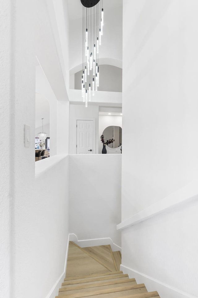 stairway featuring a towering ceiling