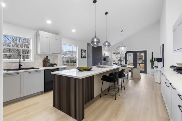 kitchen with sink, a center island, black dishwasher, tasteful backsplash, and white cabinets