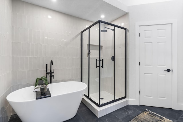 bathroom featuring independent shower and bath and tile walls