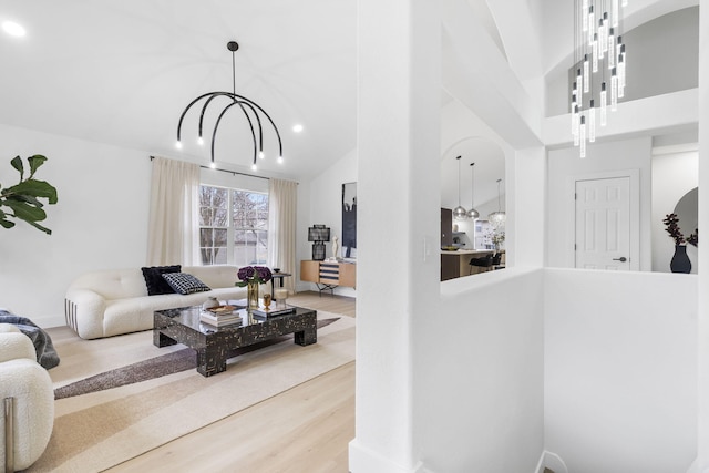 living room with hardwood / wood-style flooring, a chandelier, and high vaulted ceiling