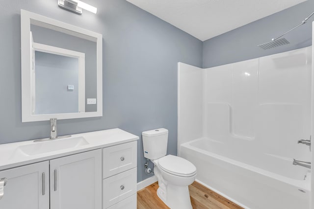 full bathroom with hardwood / wood-style flooring, vanity, shower / washtub combination, and toilet