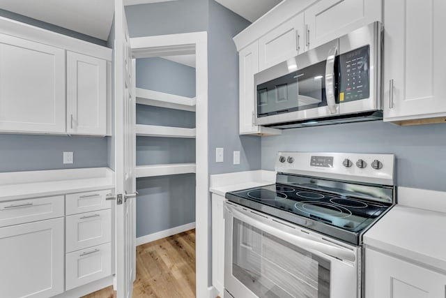 kitchen featuring white cabinetry, stainless steel appliances, and light wood-type flooring