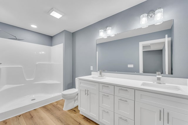 bathroom featuring walk in shower, vanity, toilet, and hardwood / wood-style floors