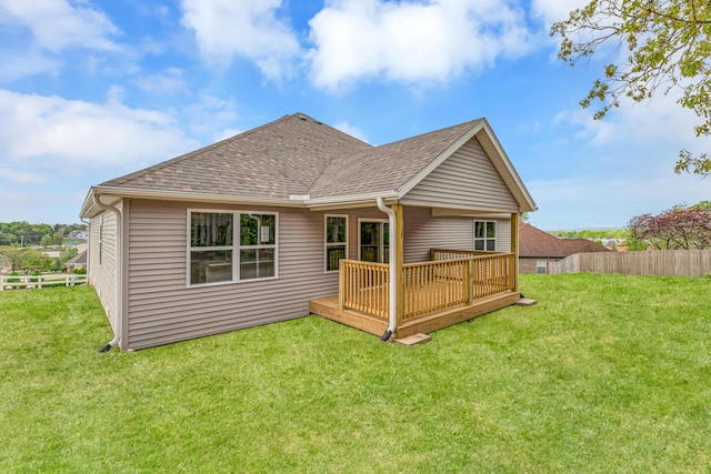 rear view of house with a deck and a lawn