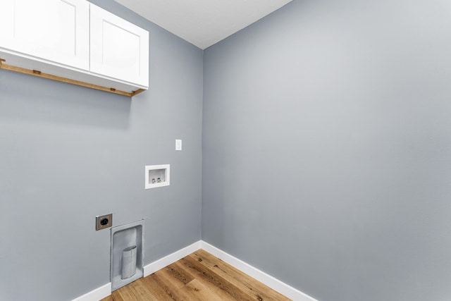 laundry area featuring cabinets, hookup for an electric dryer, light hardwood / wood-style floors, and hookup for a washing machine