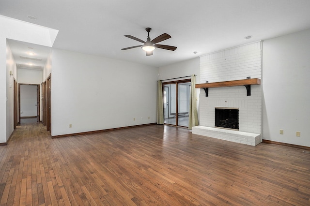 unfurnished living room with dark wood-type flooring, a fireplace, and ceiling fan