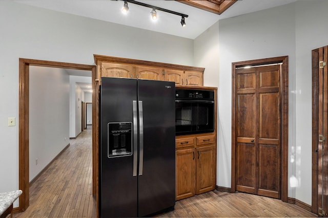 kitchen with wood-type flooring, lofted ceiling, and black appliances