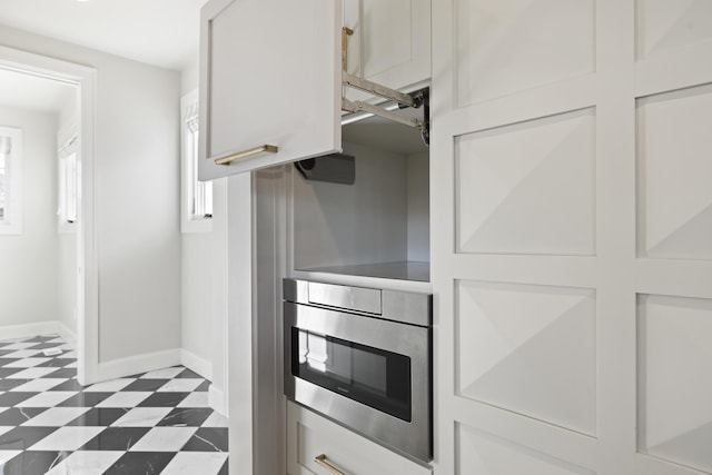 kitchen with white cabinetry, stainless steel microwave, and oven