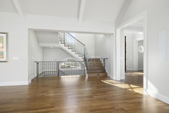 unfurnished living room with beam ceiling and dark hardwood / wood-style flooring