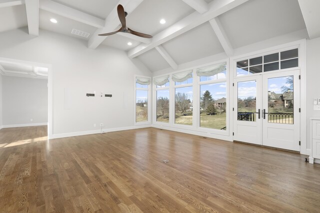 unfurnished living room featuring ceiling fan, hardwood / wood-style floors, high vaulted ceiling, french doors, and beamed ceiling