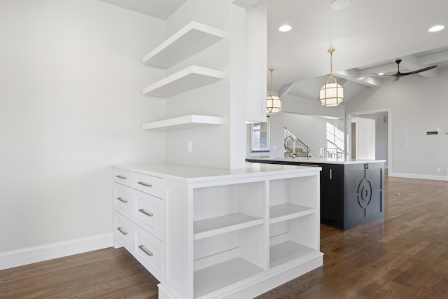 kitchen featuring hanging light fixtures, dark hardwood / wood-style floors, lofted ceiling with beams, white cabinets, and kitchen peninsula