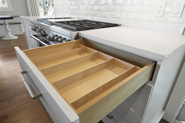 details featuring dark hardwood / wood-style flooring and stainless steel stove