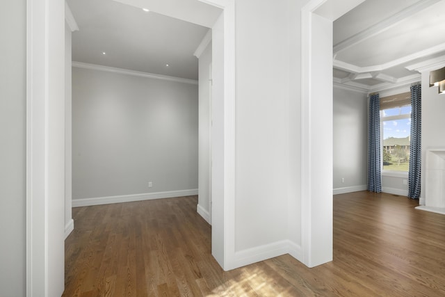 corridor with coffered ceiling, ornamental molding, and dark hardwood / wood-style floors