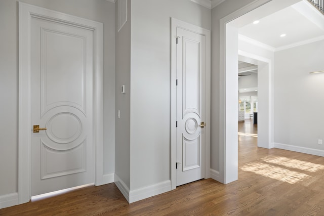 corridor featuring wood-type flooring and ornamental molding