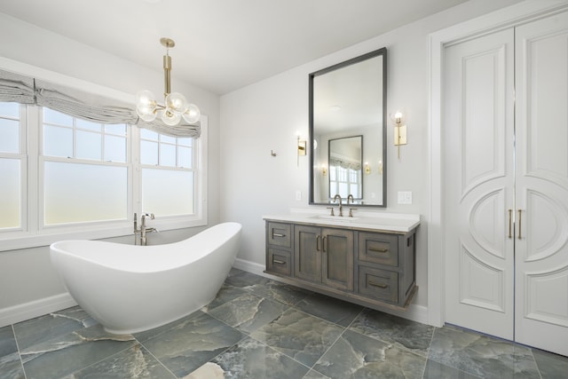 bathroom featuring a washtub, vanity, and a notable chandelier