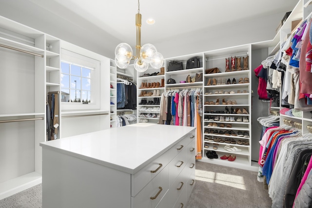 spacious closet with an inviting chandelier and light carpet