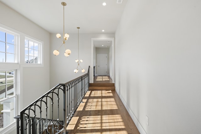 corridor with dark hardwood / wood-style flooring and a notable chandelier