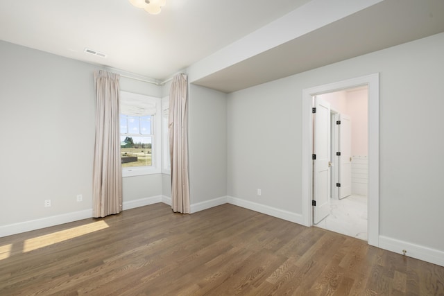 spare room with wood-type flooring