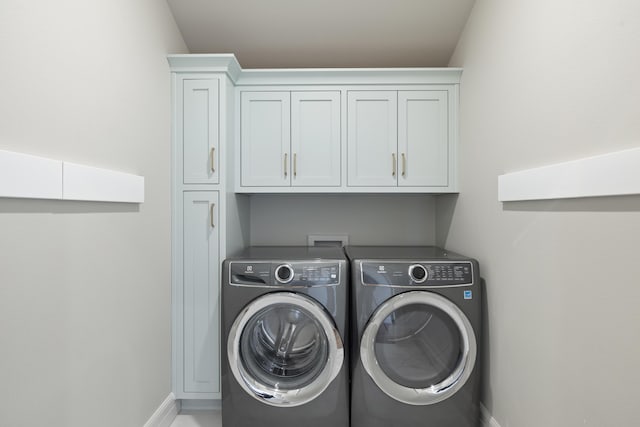 laundry room featuring cabinets and washing machine and clothes dryer