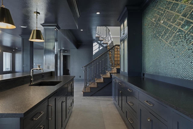 kitchen with light tile patterned flooring, sink, and decorative light fixtures